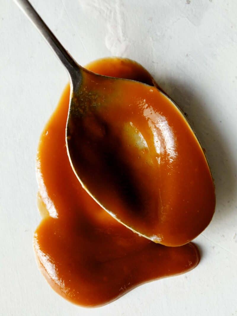 A spoonful of cajeta on a a surface so you can really see the cajeta texture.