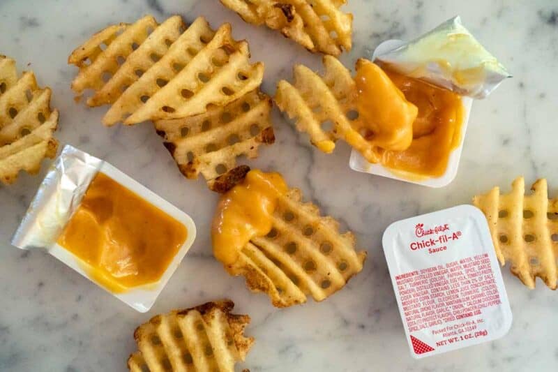 Chick fil A sauce with waffle fries on a marble counter. 