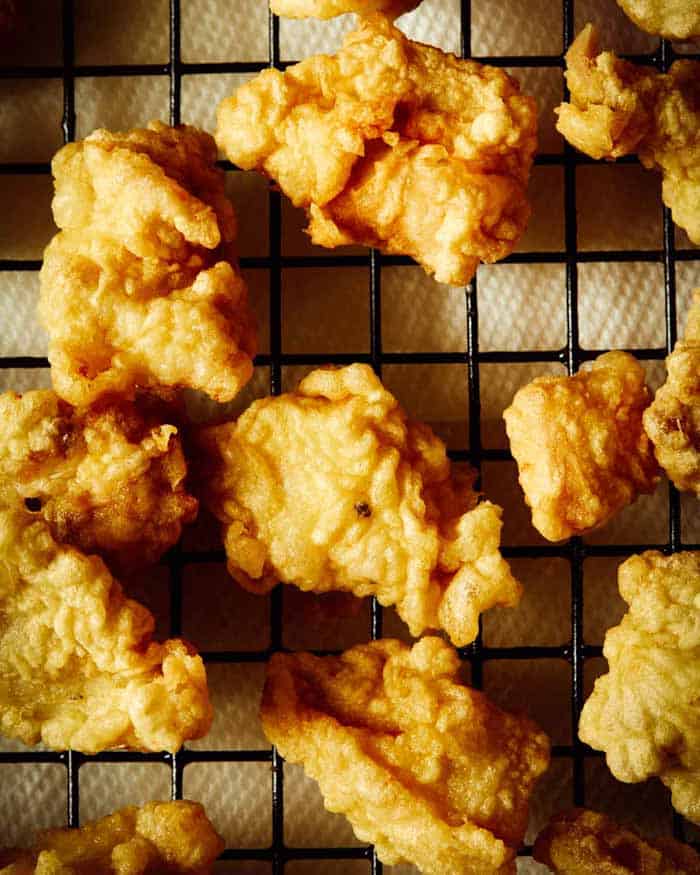 Friend chicken for sesame chicken on a drying rack with paper towels.