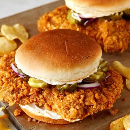 A close up of pork tenderloin sandwiches with potato chips.