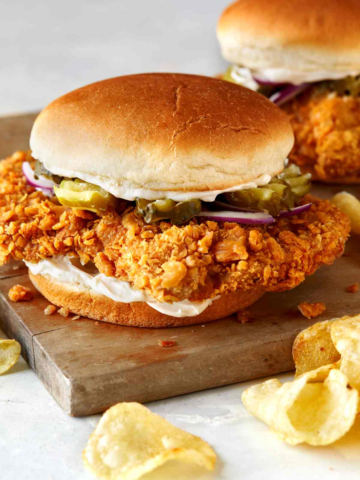 Close up on a pork tenderloin sandwich on a cutting board. 