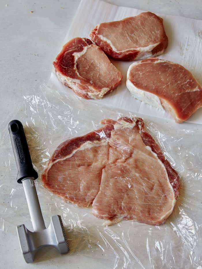 A pounded pork tenderloin with three more in the background.