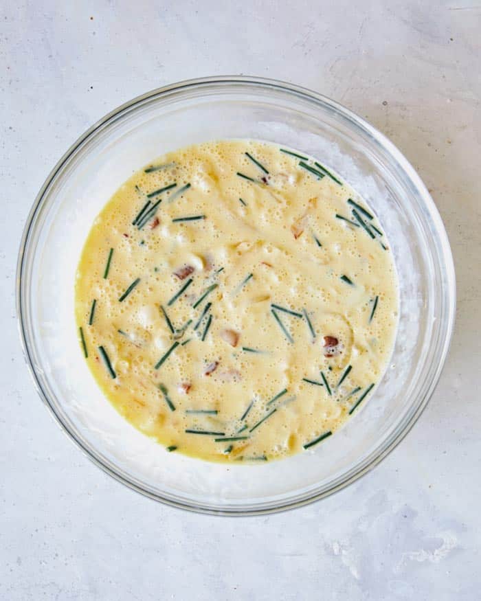 Quiche filling mixture in a mixing bowl combined.