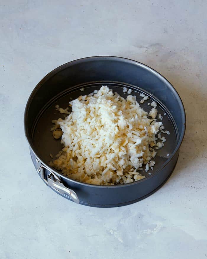 Hash brown crust mixture in a springform pan.