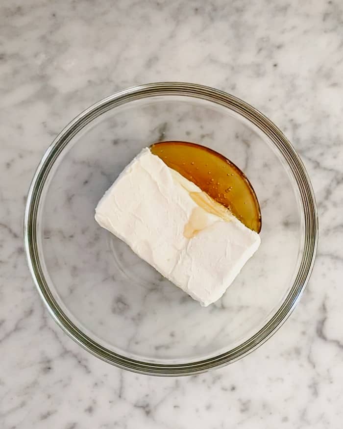 A bowl full of cream cheese with honey.