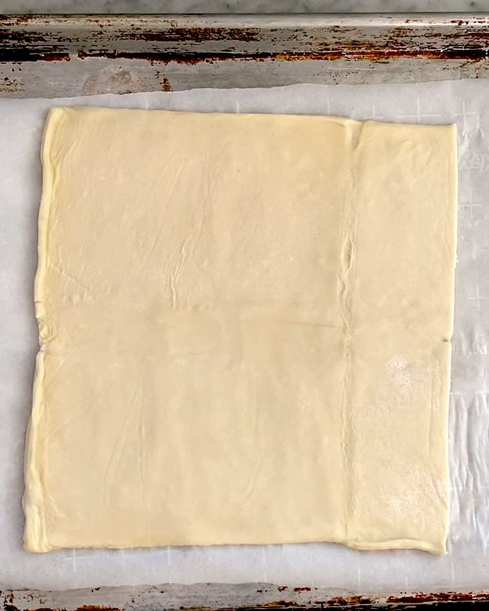Raw puff pastry on a baking sheet. 