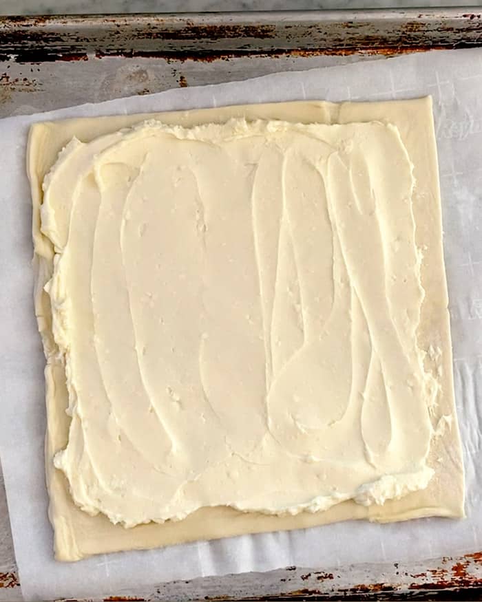 Raw puff pastry spread with honey and cream cheese.