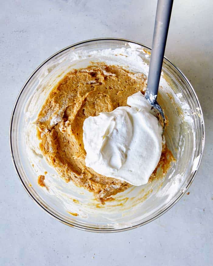 Adding whipped cream in thirds to the peanut butter pie filling.