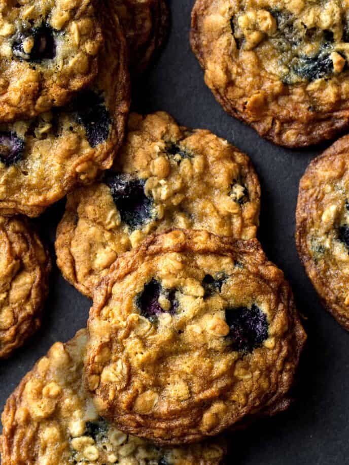 Blueberry Cardamom Oat Cookies stacked on a surface. 