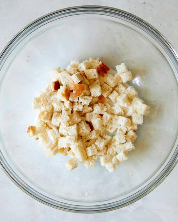 Cubed white bread soaking in milk.