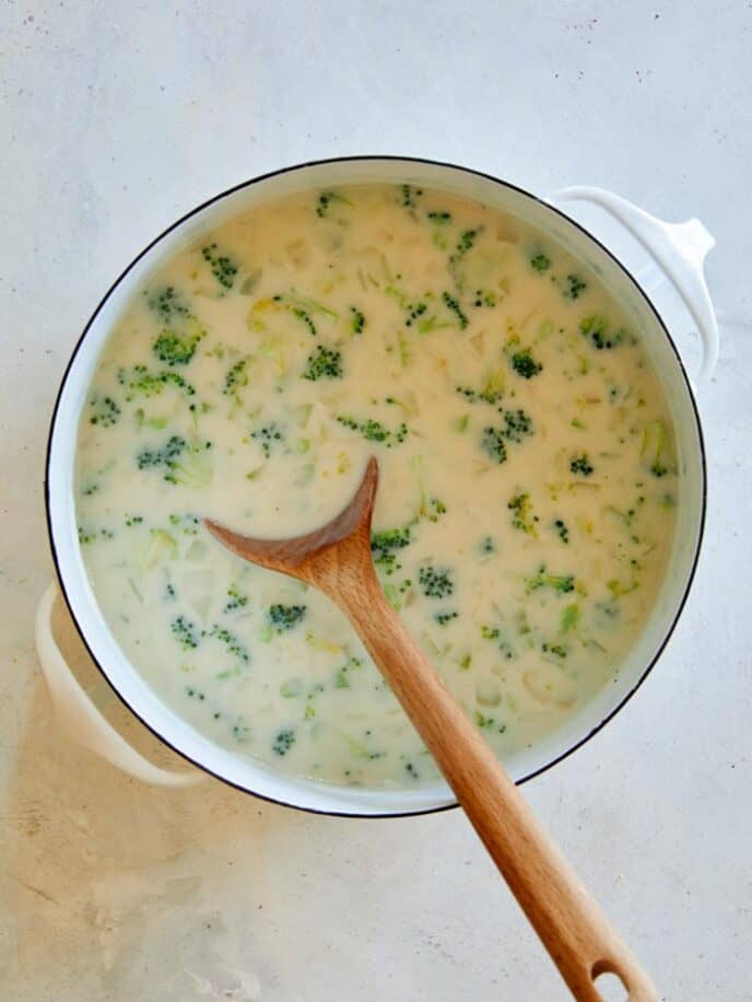 Milk added into a stock pot with broccoli cheddar soup.