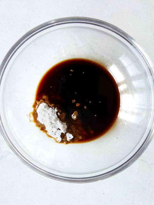 Making chow mien sauce, cornstarch and soy sauce in a glass bowl.