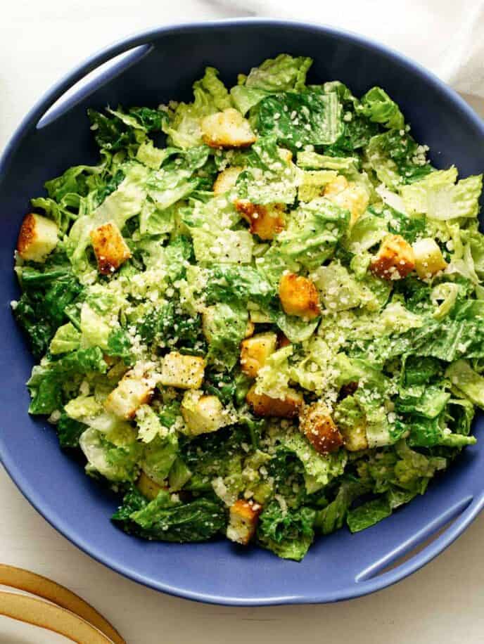 Classic caesar salad recipe in a blue serving dish.