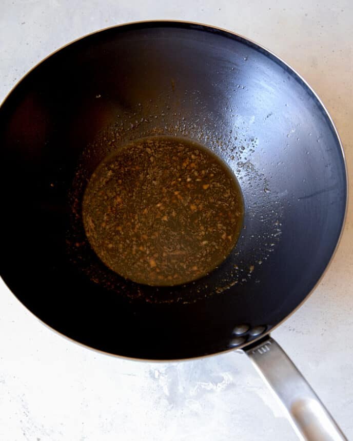 Fish sauce and soy sauce in a wok with garlic and butter.