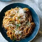 Two bowls of garlic noodles with forks on the side.