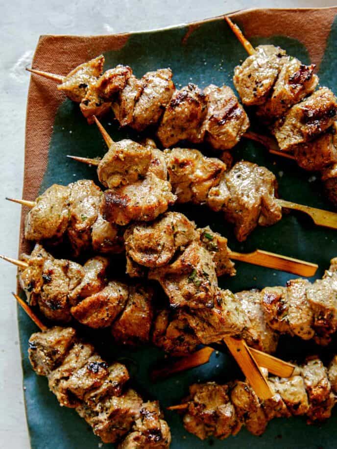 A platter of grilled lamb kabobs up close.