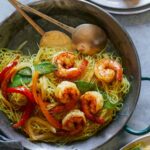 Singapore noodles on a platter with a service ware next to it.