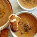 Three bowls of leftover vegetable soup and some toasted bread.