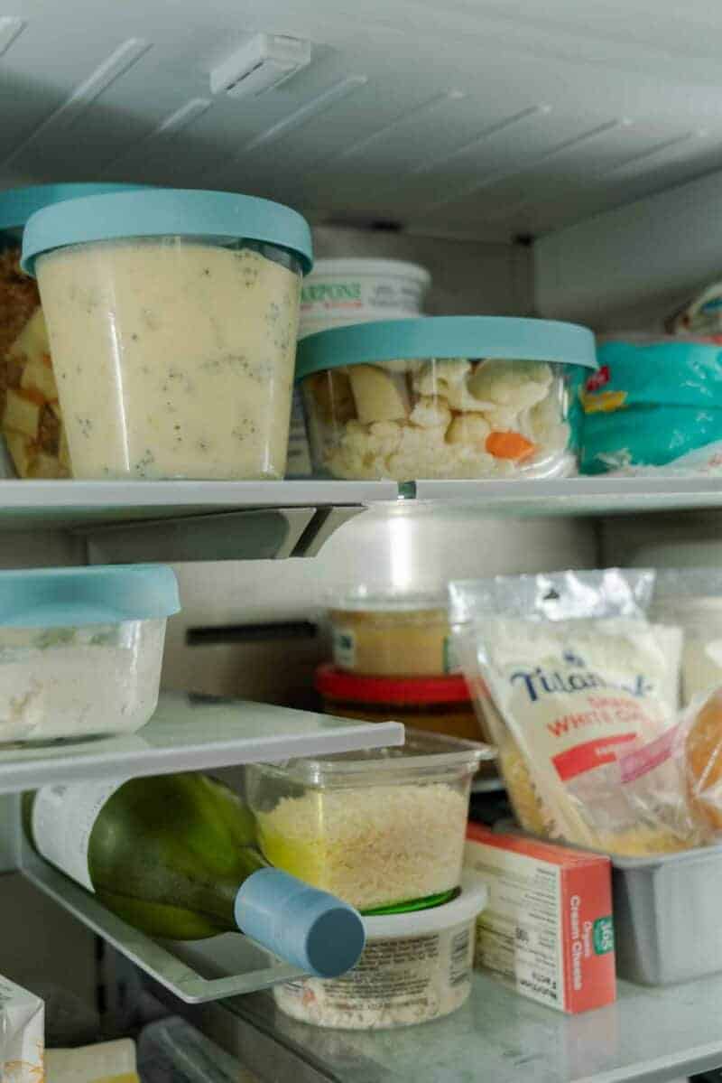 A close up view of the inside of a refrigerator and some tupperware. 