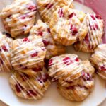 A stack of Strawberry shortcake cookies on a pink plate.