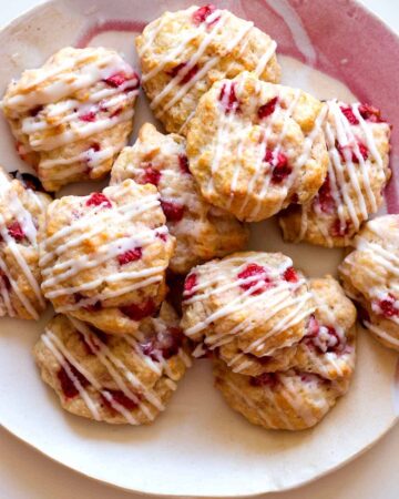 A stack of Strawberry shortcake cookies on a pink plate.