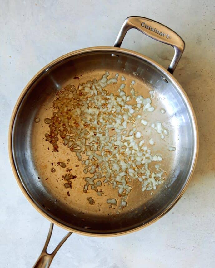 A pan of garlic cooking on a kitchen counter. 