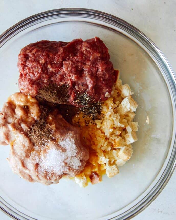 Swedish Meatballs in a glass bowl ready to be mixed. 