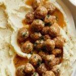 Close up on Swedish Meatballs recipe on a plate with mashed potatoes.