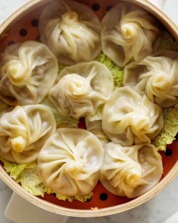 Shanghai Soup Dumplings in a steamer with cabbage.