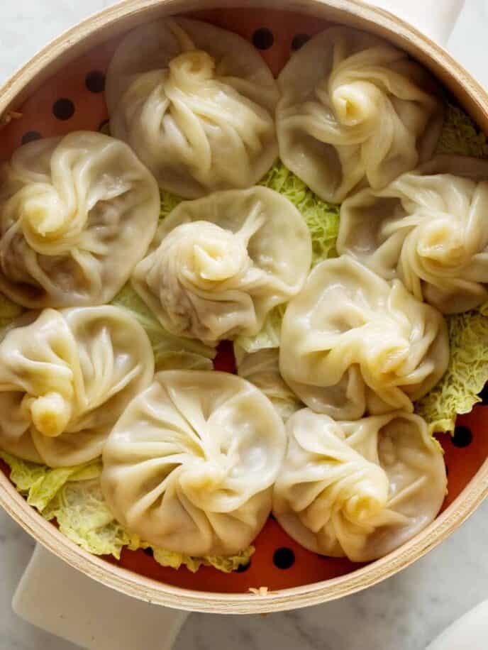 Shanghai Soup Dumplings in a steamer with cabbage. 