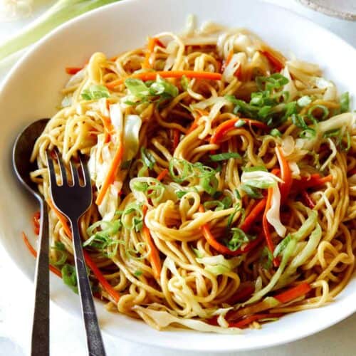 Chow Mein Noodles in a big bowl with a fork and spoon in it to serve.