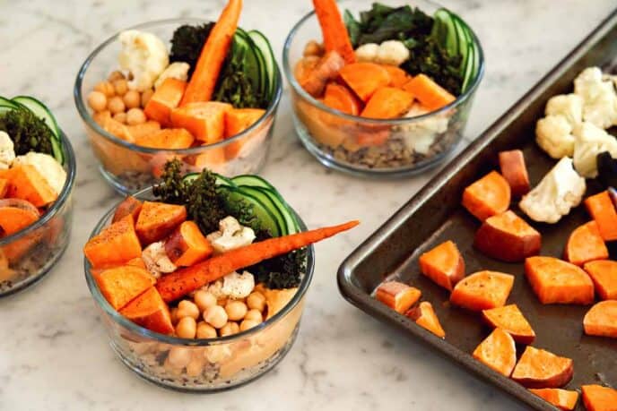 Assembling grain bowls on a kitchen counter. 