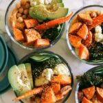 Four meal prep grain bowls in tupperware containers.