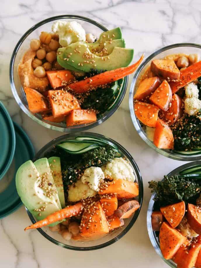 Four meal prep grain bowls in tupperware containers. 