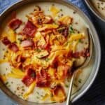 Loaded Baked Potato Soup close up in a bowl with a spoon in it.