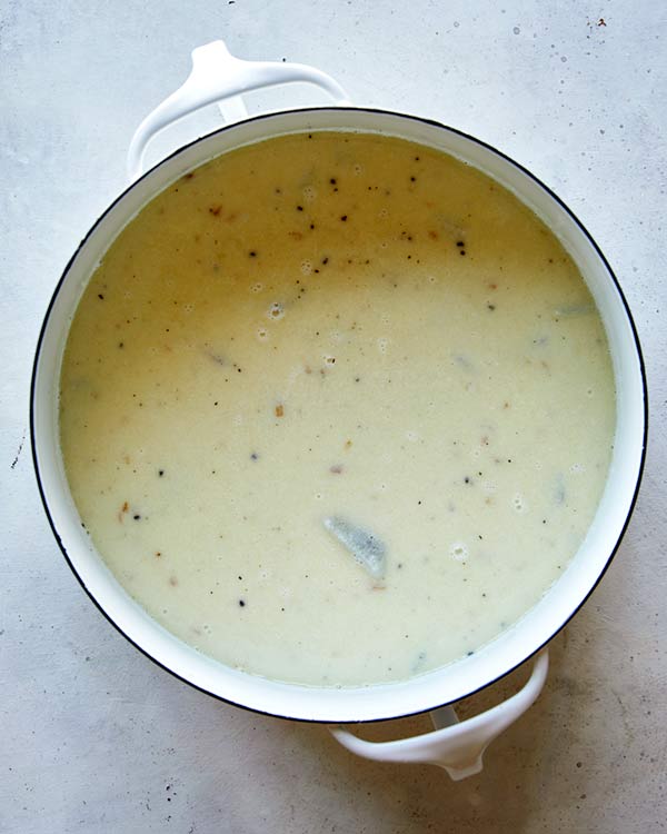 Baked potatoes simmering in a stock pot to make Loaded Baked Potato Soup.