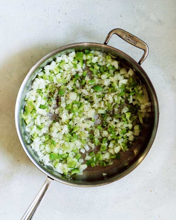 Sauted onion and green bell peppers in a skillet.