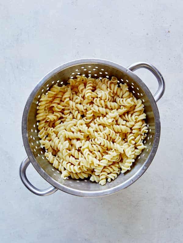 Cooked and drained fusilli pasta in a colander.