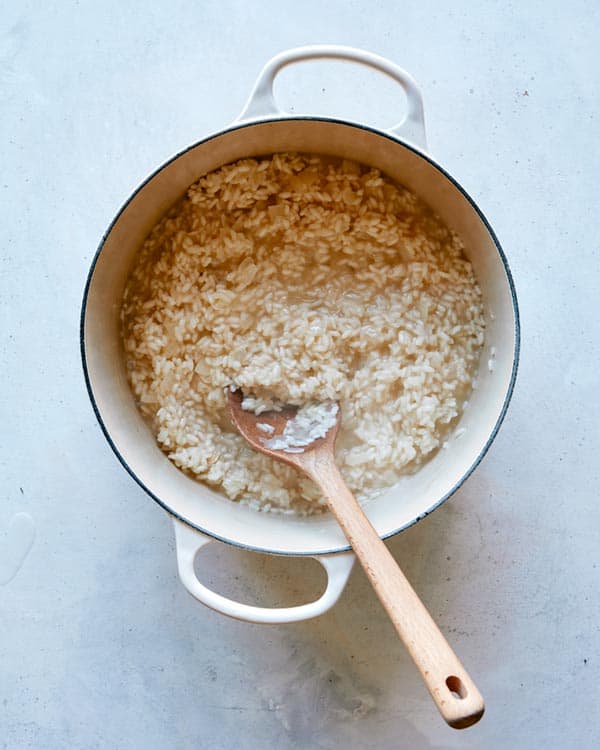 Add all of the broth into the pot until the rice has soaked it all up.