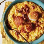 Pumpkin risotto with scallops and pancetta in a bowl.