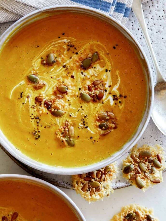 Creamy Pumpkin Soup overhead in a bowl with another bowl peeking in the frame. 