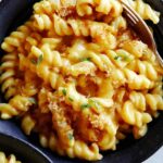 A bowl of pumpkin mac and cheese for a fork in the pasta.