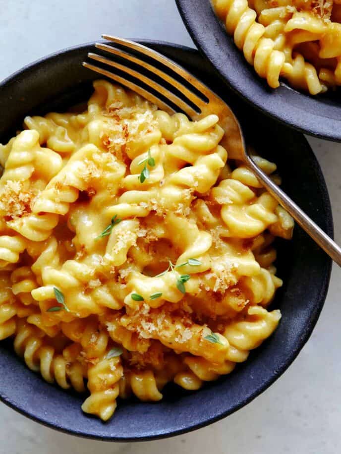 Pumpkin Mac and Cheese served into two bowls with a fork in one.