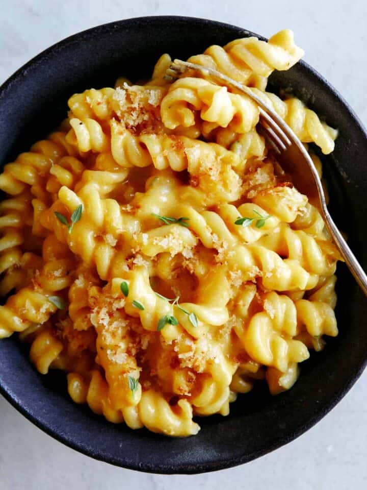 A bowl of pumpkin mac and cheese for a fork in the pasta.