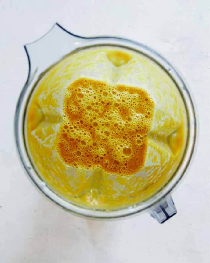 Pumpkin soup mixture in a blender shot overhead.