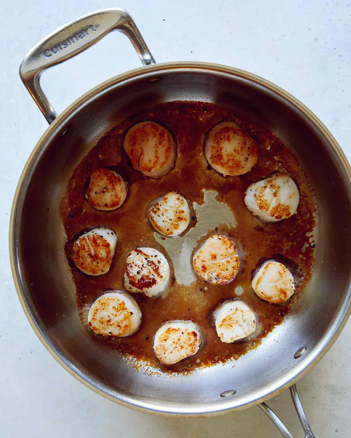 Seared scallops in a skillet.