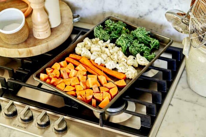 A baking sheet full of cooked vegetables ready to go into an oven. 