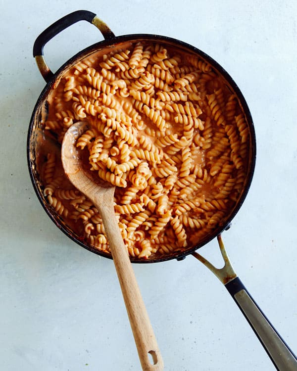 A skillet full of pasta and vodka sauce.