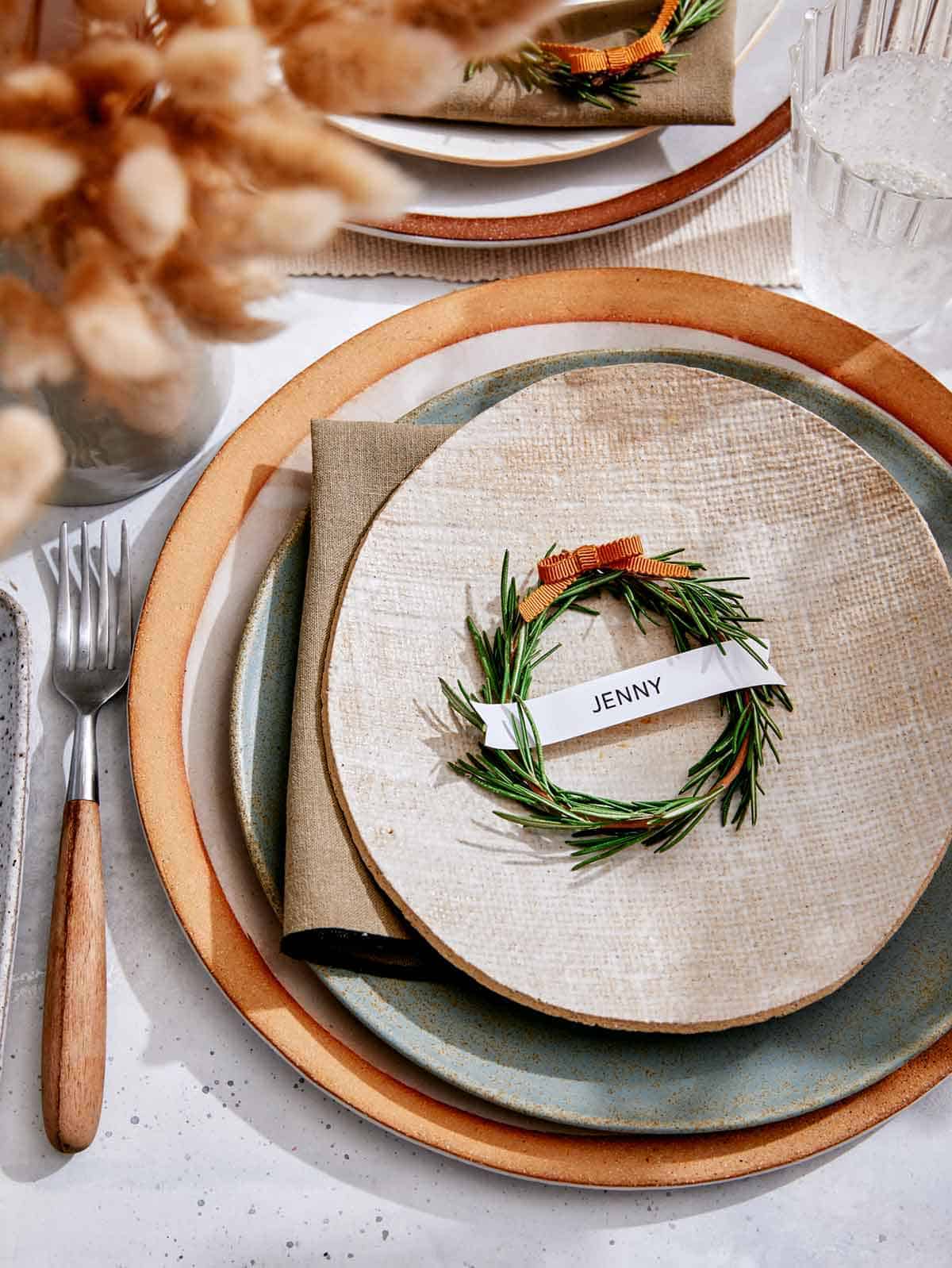 Rosemary Wreath Place Card on a plate in a table setting. 