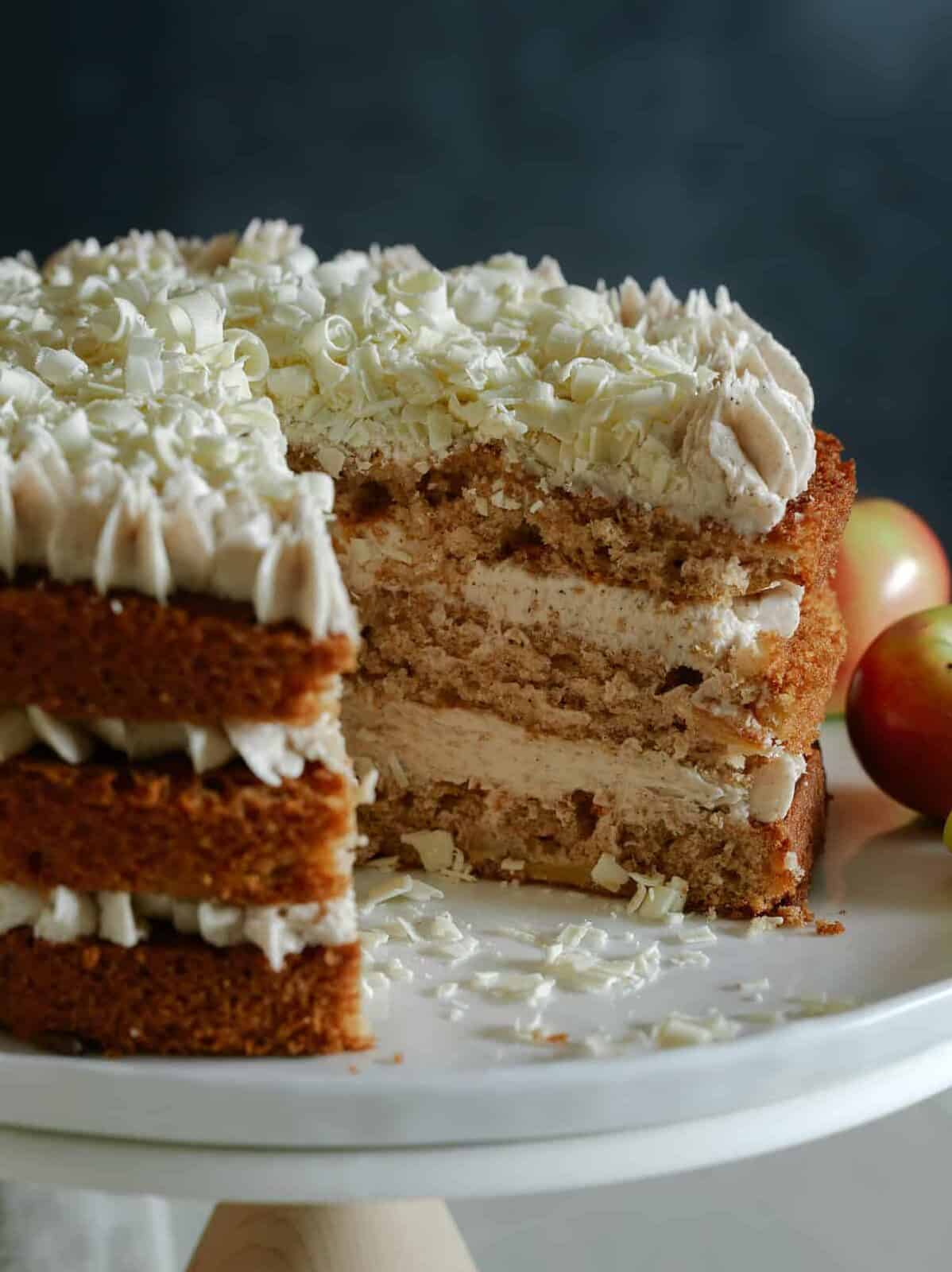 A close up of an apple cake with chai buttercream frosting with visible interior layers.